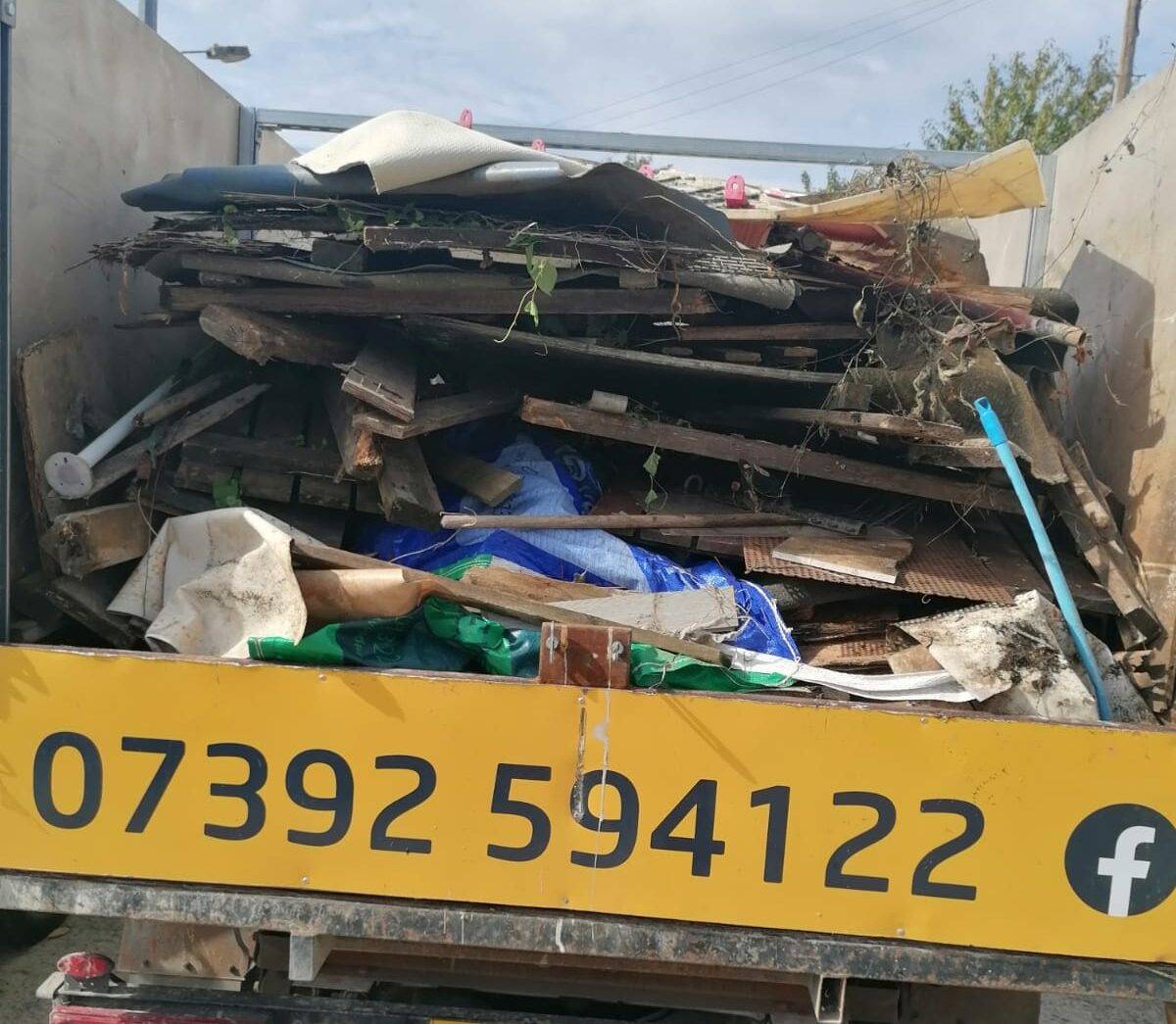 Image showing a van from Essex Waste Man filled with rubbish after a house clearance, with various household items and waste visibly stacked in the back."