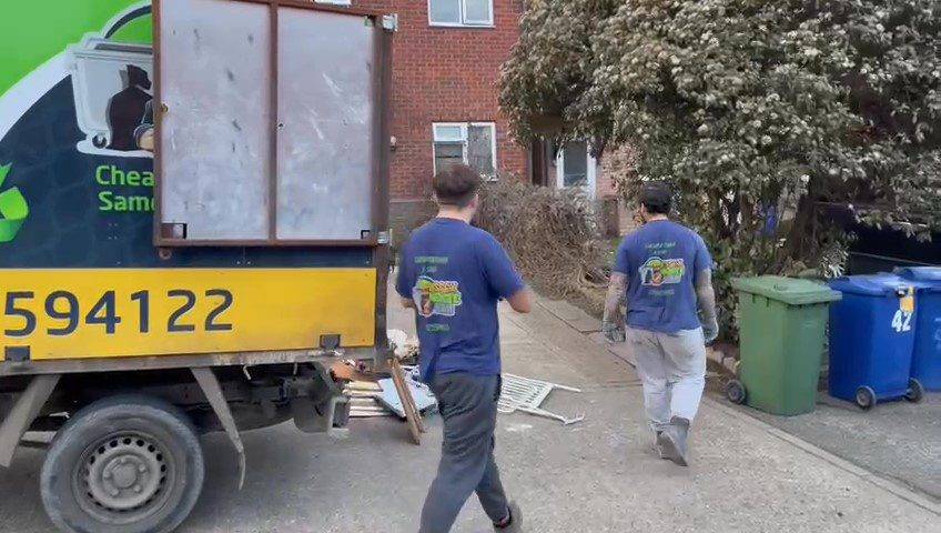 Two rubbish removal men wearing Essex Waste Man branded clothing with the work van and waste seen in the picture